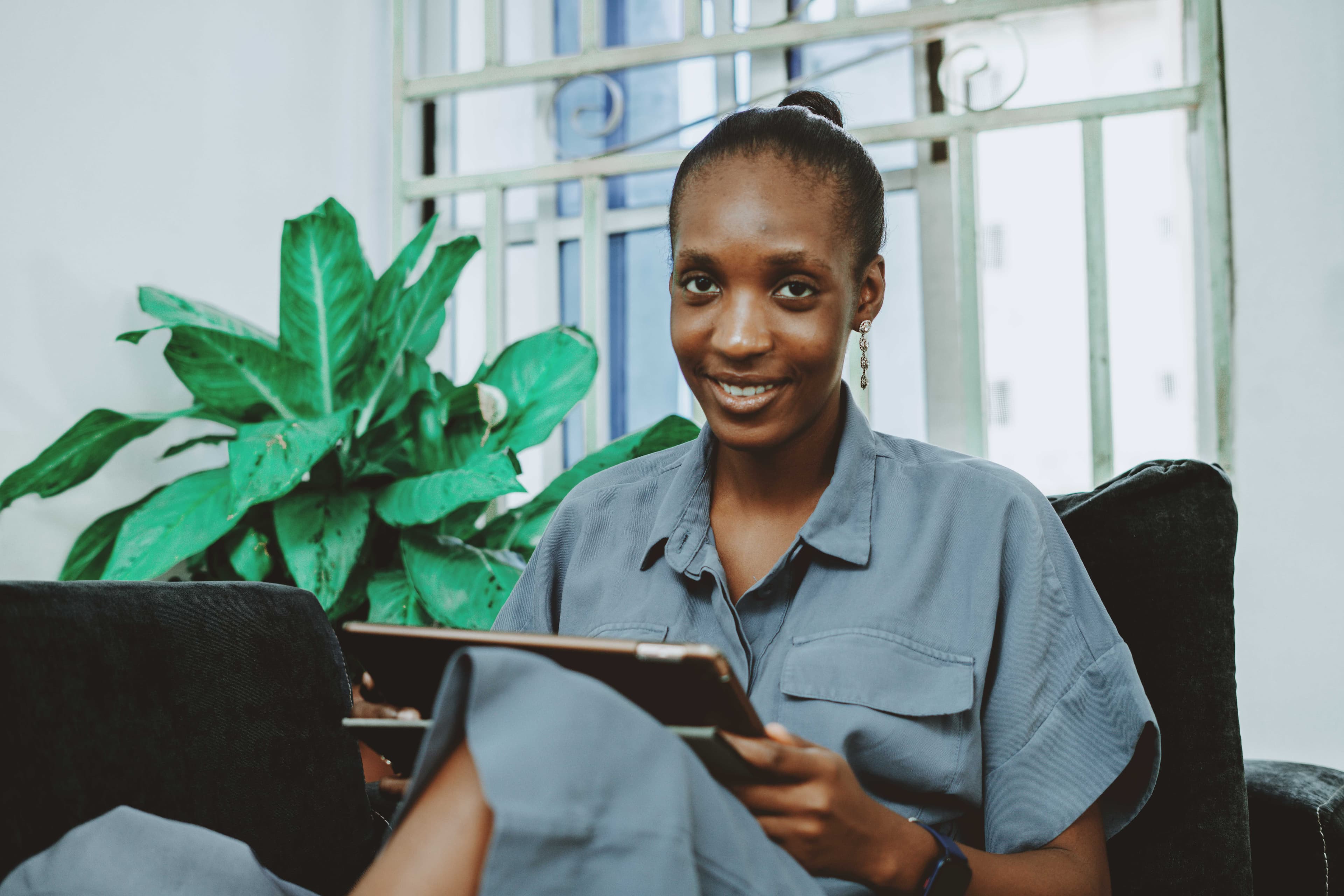 South Sudanese mobile money agent smiling at her phone using Finnotes